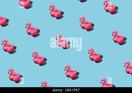 Motif tendance avec flamants roses gonflables sur fond bleu Banque D'Images