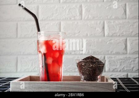 Un verre de thé de rose glacé avec feuille de thé séchée. Banque D'Images