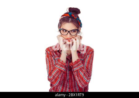 Neurotique femme mordant des ongles nerveux. Portrait en gros plan d'une belle fille en chemise à carreaux rouges et jeans avec noeud rétro sur la tête isolée sur le blanc ba Banque D'Images