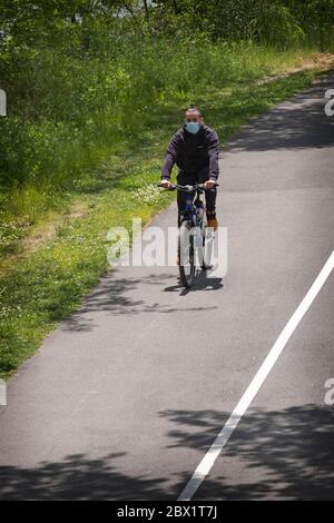 Un cycliste avec un vélo à tête partiellement rasé sur le sentier près de la Marina Bayside à Queens, New York. Banque D'Images