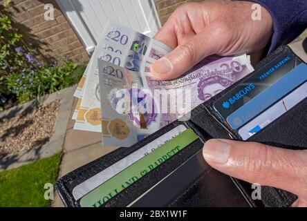 Gros plan de la personne de l'homme prenant payer anglais £20 livres livres billets argent comptant de hors du portefeuille Angleterre Royaume-Uni GB Grande-Bretagne Banque D'Images