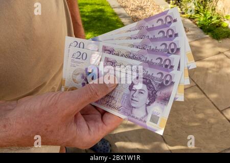 Gros plan de la main de l'homme tenant £20 vingt livres billets de banque billets argent comptant coût de la vie concept crise Angleterre Royaume-Uni Grande-Bretagne Banque D'Images