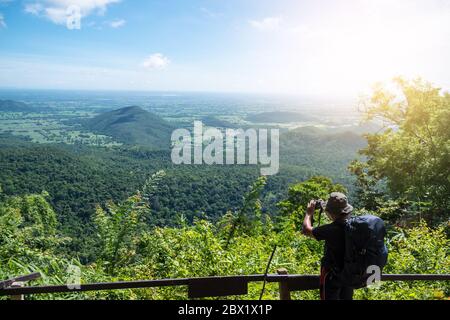 Homme voyageur prenant des photos sur le sommet de la montagne avec le ciel bleu. Banque D'Images