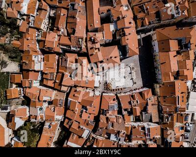 Vue aérienne de haut en bas de drone sur la ville de Piran avec des rues étroites, des bâtiments anciens avec des toits rouges et la Piazza 1. Maggio dans le sud-ouest de la Slovénie Banque D'Images