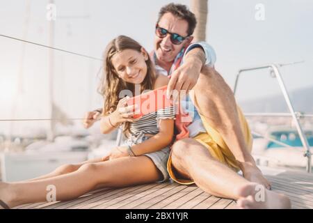 Père et fille prenant l'appareil photo de smartphone selfie pendant le voyage en voilier - famille heureuse de s'amuser avec la nouvelle application mobile pour les médias sociaux en vacances Banque D'Images