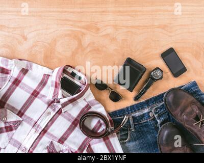 Vue de dessus de l'homme tenues décontractées avec accessoires sur fond de table en bois Banque D'Images