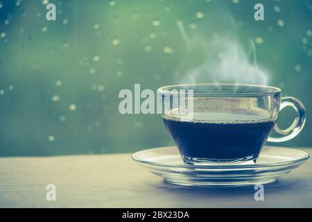 Tasse de café sur la table à l'intérieur de la fenêtre, pause-café le matin avec jour de pluie, concepts relaxants et rafraîchissants. Banque D'Images