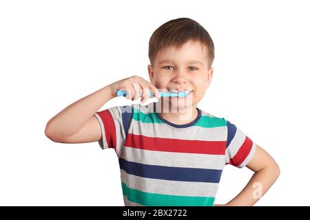 Un garçon souriant se brosse les dents, isolé sur un fond blanc. Banque D'Images