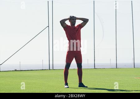 Homme afro-américain de football debout sur le terrain Banque D'Images