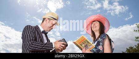 Gros plan à l'angle bas du Royaume-Uni Happy couple en costume vintage des années 1940 en plein air sous le soleil d'été. L'homme photographie sa femme avec l'appareil photo Box Brownie vintage. Banque D'Images