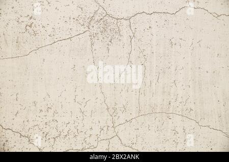 Surface murale gris clair, ancienne et fissurée. Gros plan sur un mur peint en plâtré. Banque D'Images