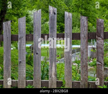 Clôture de la maison. Protéger la propriété. Dans le fond de verdure, herbe et prairies Banque D'Images