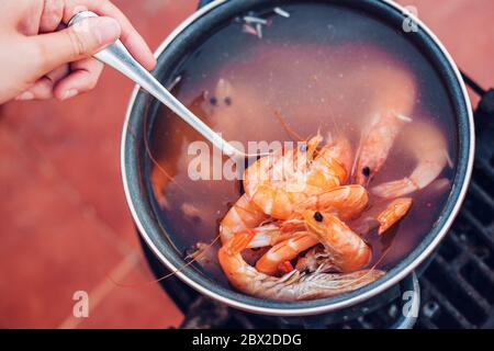 Les crevettes sont cuites dans une casserole sur un barbecue - de grandes langoustines dans de l'eau bouillante Banque D'Images