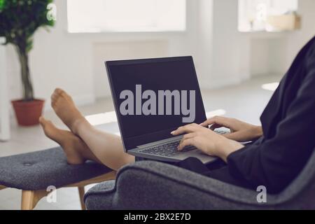 Crop femme d'affaires travaillant en ligne avec un ordinateur portable à la maison. Banque D'Images