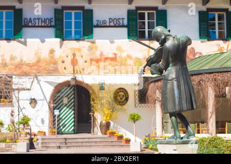 St.Gilgen, Autriche - 5 avril 2020 : statue du jeune Wolfgang Amadeus Mozart près du bâtiment historique du Gasthof zum Post (Guesthous à la poste) à Mozart Banque D'Images