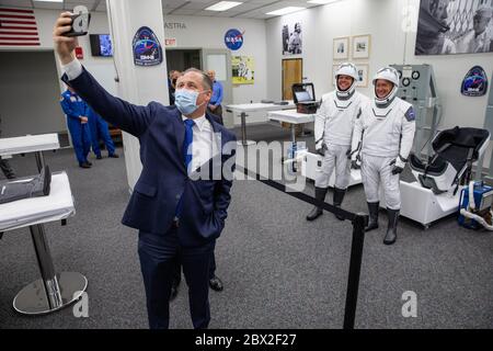 Jim Bridenstine, administrateur de la NASA, pose un selfie aux astronautes Robert Behnken, à gauche, Et Douglas Hurley, à droite, dans leurs espaces SpaceX, après avoir poursuivi dans le bâtiment Neil Armstrong Operations and Checkout pour lancer le complexe 39A pour le lancement de la mission Demo-2 au Kennedy Space Center le 30 mai 2020 Cape Canaveral, en Floride. Les astronautes feront une deuxième tentative de lancement lors du premier lancement commercial transportant des astronautes à la Station spatiale internationale. Banque D'Images