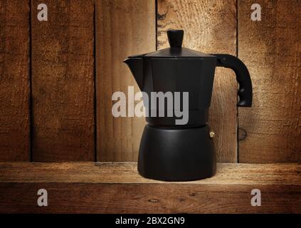 Machine à café italienne noire geyser isolée sur fond de bois Banque D'Images