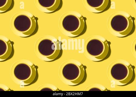 Motif de tasses de café ou de thé noir sur fond jaune. Banque D'Images