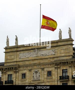 Bâtiment du siège de la banque Santander (Banco de Santander) avec un gros plan du drapeau national espagnol à mi-mât pendant 10 jours de deuil Banque D'Images