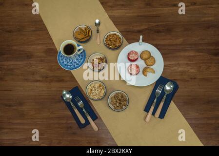 Petit déjeuner, biscuits, fruits secs, couteau et fourchette sur table en bois Banque D'Images