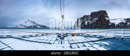 Antarctique, Océan Austral, archipel des îles Shetland du Sud, navigation sous la neige près des Forges de Neptune, le seul point d'entrée dans la caldeira effondrée de l'île Deception, vue panoramique depuis la prow du bateau de croisière polaire MS Fram de la compagnie norvégienne Hurtigruten Banque D'Images