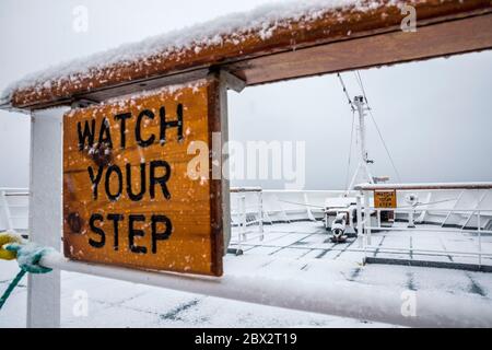 Antarctique, Océan Austral, archipel des îles Shetland Sud, navigation sous la neige près des Forges de Neptune, le seul point d'entrée dans la caldeira effondrée de l'île Deception, l'arc du bateau de croisière polaire MS Fram de la compagnie norvégienne Hurtigruten Banque D'Images