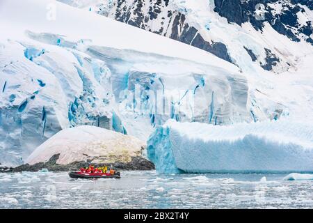 Antarctique, Océan Austral, Péninsule Antarctique, Graham Land, chenal Lemaire, exploration du chenal entre icebergs à la recherche de la vie marine dans un petit bateau semi-rigide, un glacier en arrière-plan Banque D'Images