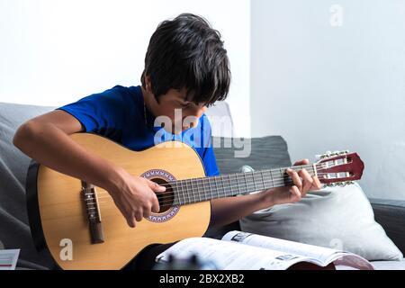 Un adolescent joue de la guitare à la maison Banque D'Images