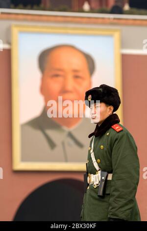 Chine, municipalité de Pékin, ville de Pékin, Cité interdite, classée au patrimoine mondial de l'UNESCO, entrée principale, gros plan d'un jeune soldat debout devant un portrait géant de Mao Zedong Banque D'Images