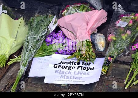 Des fleurs et une note appelant à la justice ont été laissées à côté d'une fresque représentant George Floyd, peinte par l'artiste de rue Akse, qui a récemment paru sur Stevenson Square, dans le centre de Manchester, en Angleterre, au Royaume-Uni. Floyd, un homme afro-américain, est décédé à Minneapolis, Minnesota, États-Unis, le 25 mai 2020, alors qu'il était arrêté par 4 policiers après qu'un assistant de magasin ait prétendu avoir essayé de payer avec une fausse facture de 20 $. Banque D'Images