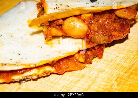 Quesadilla avec bœuf haché, saucisse, haricots rouges, maïs doux, oignon et sauce tomate. Un repas mexicain traditionnel. Gros plan Banque D'Images