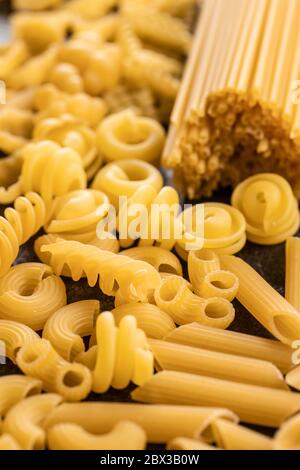 Divers types de pâtes italiennes crues sur la table de cuisine. Banque D'Images