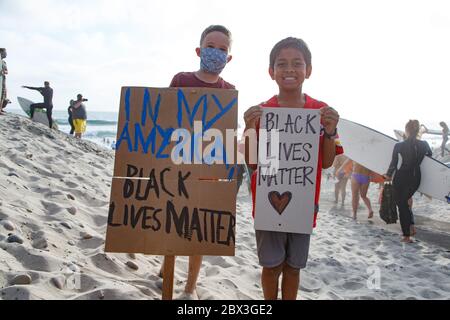 Deux garçons présentent des signes de protestation lors d'une manifestation Black Lives Matter à Moonlight Beach à Encinitas, en Californie. Banque D'Images