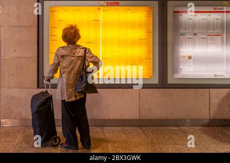 Un voyageur étudie l'horaire affiché à la gare centrale de Cologne, en Allemagne Banque D'Images
