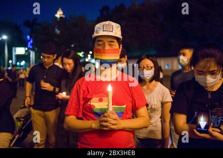 Un homme portant un masque arc-en-ciel tout en tenant une bougie pendant la commémoration. Les Chinois du monde entier organisent chaque année des commémorations dans les grandes villes du monde entier pour commémorer les morts sur la place Trainmen de Pékin il y a 31 ans lors d'une manifestation antigouvernementale. Banque D'Images