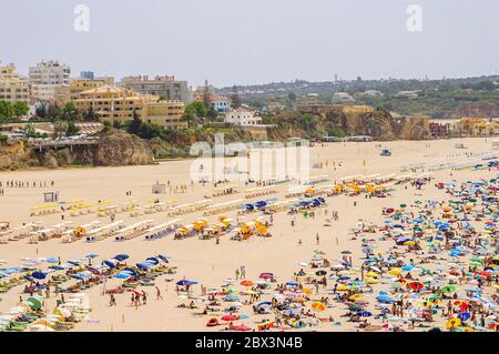 Vue sur la plage Praia da Rocha à Portimao avec chaises longues, chaises longues et parasols en été, ouest de l'Algarve, sud du Portugal Banque D'Images