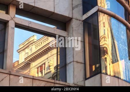 Bâtiment d'architecture classique compte déformée dans un bâtiment moderne en verre. Vs moderne de l'âge. Belgrade, Serbie. Résumé image images Banque D'Images