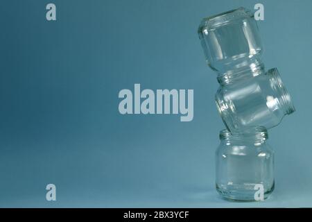 Ligne courbe verticale des pots en verre sur fond bleu à droite. Banque D'Images