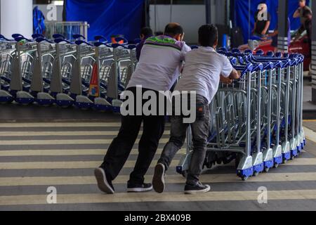 KUALA LUMPUR, MALAISIE - 15 mai 2017 : un travailleur non identifié pousse des chariots au terminal de l'aéroport international KLIA 2. Banque D'Images