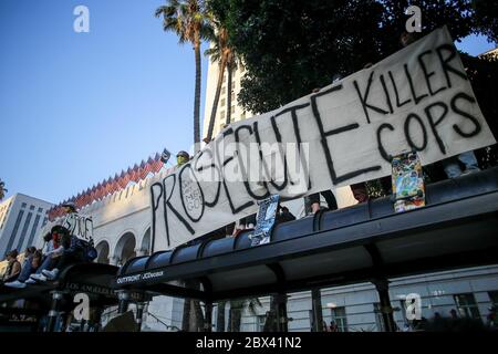 Los Angeles, États-Unis. 03ème juin 2020. Les manifestants tiennent une bannière qui dit, poursuivre les flics de Killer devant l'hôtel de ville de Los Angeles pendant la manifestation. Les manifestants de Los Angeles se sont rassemblés devant l'hôtel de ville de Los Angeles pour protester contre la mort de George Floyd. La manifestation a rassemblé une foule de 10,000 personnes environ et la manifestation a été entièrement pacifique mais à la fin du rassemblement, environ 150 manifestants pacifiques ont été arrêtés pour avoir refusé de quitter l'hôtel de ville de Los Angeles après la mise en place du couvre-feu du comté de Los Angeles. Crédit : SOPA Images Limited/Alamy Live News Banque D'Images