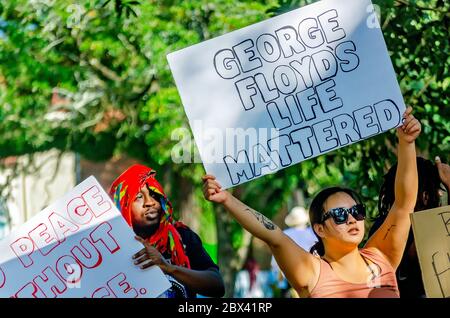 Une femme tient un panneau alors qu'elle proteste contre la brutalité policière, le 4 juin 2020, à Memorial Park à Mobile, Alabama. Banque D'Images