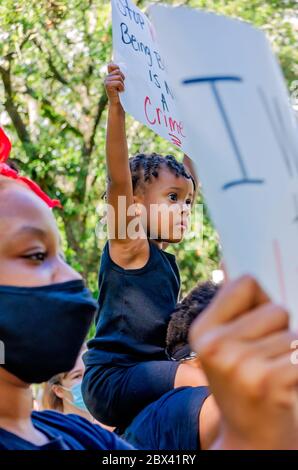 Un jeune enfant afro-américain tient un signe lors d'une manifestation contre la brutalité policière, le 4 juin 2020, à Memorial Park à Mobile, Alabama. Banque D'Images