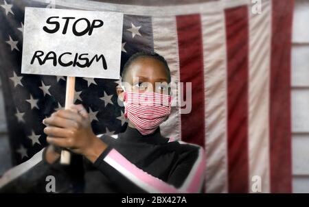 Arrêter le racisme une jeune militante noire protestant contre le gouvernement des États-Unis - une jeune femme afro-américaine indignée et hippster tient une bannière de protestation exigeant Banque D'Images