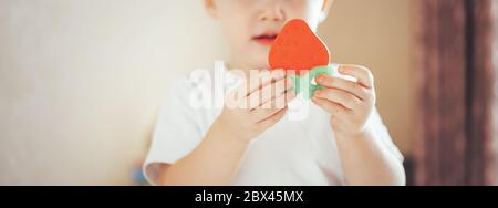 Bébé Enfant couché sur le ventre avec dentition couche portés par... Banque D'Images