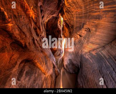 Une longue exposition de lumière douce et chaude filant dans tunnel Slot Canyon dans le Grand Staircase-Escalante National Monument dans l'Utah. Banque D'Images