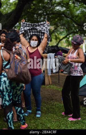 Un groupe de femmes vénézuéliennes bloquées se réunit pour distribuer des vêtements privés dans le camp de fortune créé dans le contexte de la pandémie de Covid-19, où elles ont été conçues Banque D'Images