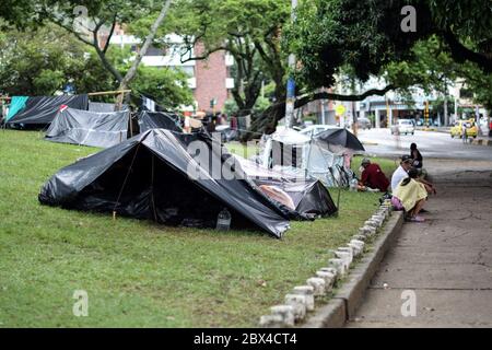 Les Vénézuéliens bloqués construisent un camp de fortune dans un parc couvert d'arbres au milieu de la pandémie de Covid-19, en attendant l'occasion de retourner dans leur pays, Cali, Banque D'Images