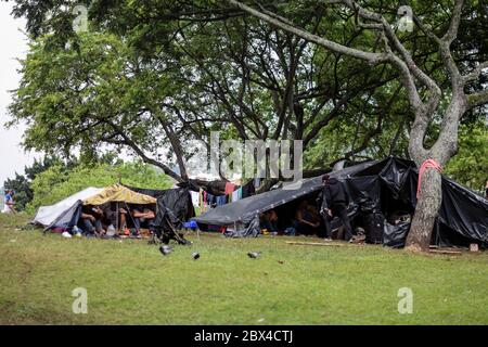 Les Vénézuéliens bloqués construisent un camp de fortune dans un parc couvert d'arbres au milieu de la pandémie de Covid-19, en attendant l'occasion de retourner dans leur pays, Cali, Banque D'Images