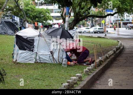 Les Vénézuéliens bloqués construisent un camp de fortune dans un parc couvert d'arbres au milieu de la pandémie de Covid-19, en attendant l'occasion de retourner dans leur pays, Cali, Banque D'Images