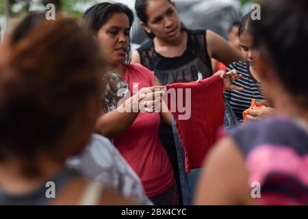 Un groupe de femmes vénézuéliennes bloquées se réunit pour distribuer des vêtements privés dans le camp de fortune créé dans le contexte de la pandémie de Covid-19, où elles ont été conçues Banque D'Images